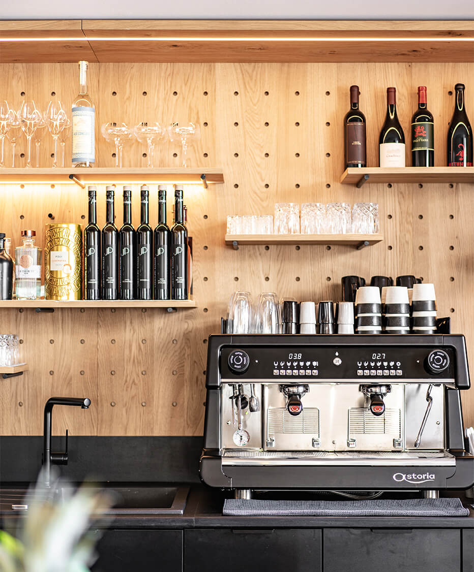 Professionelle Siebträgermaschine mit Loch Barückwand aus Holz und Flaschenborden im "Das kleine Bistro" 